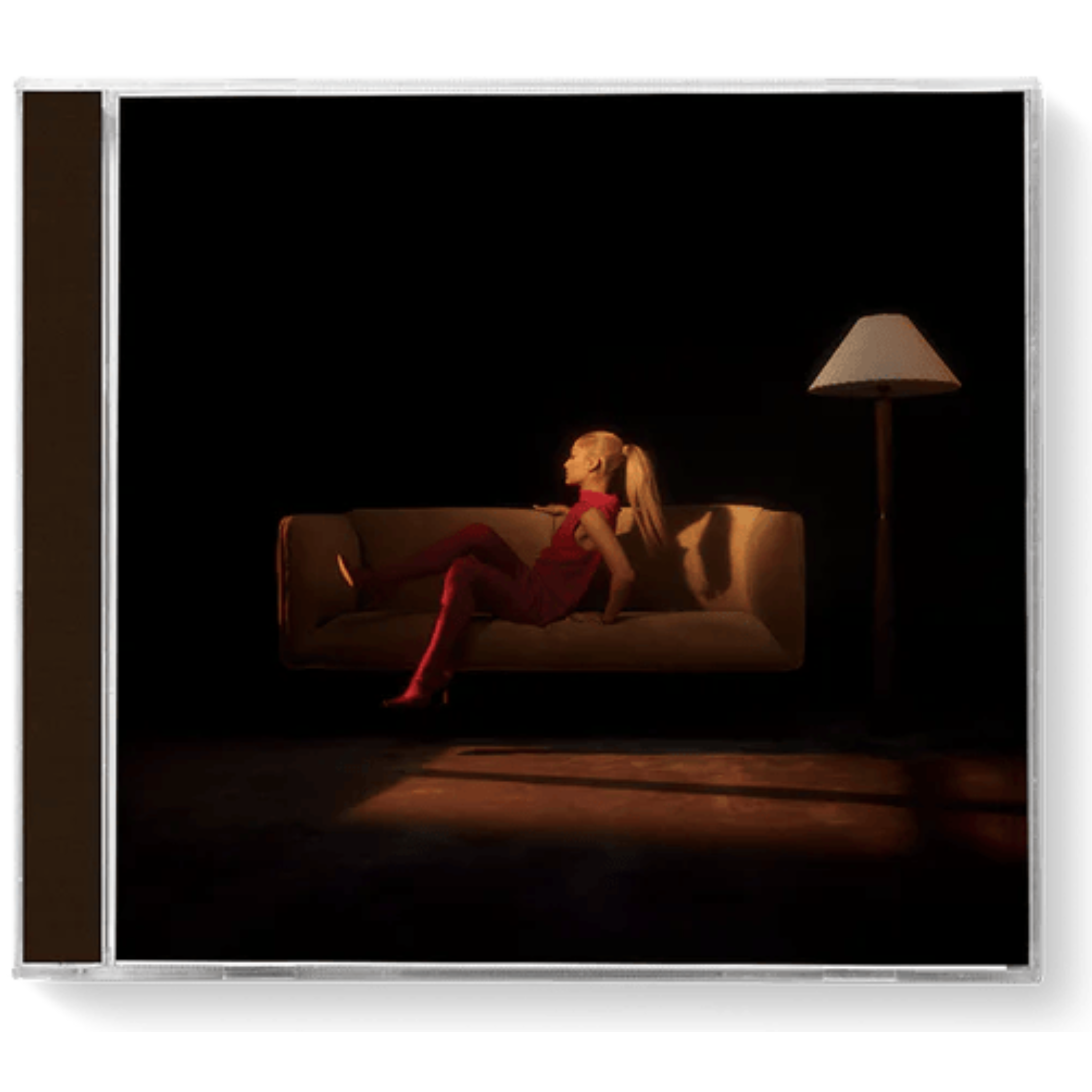 Woman in a red dress sitting on a couch in a dimly lit room with a lamp.